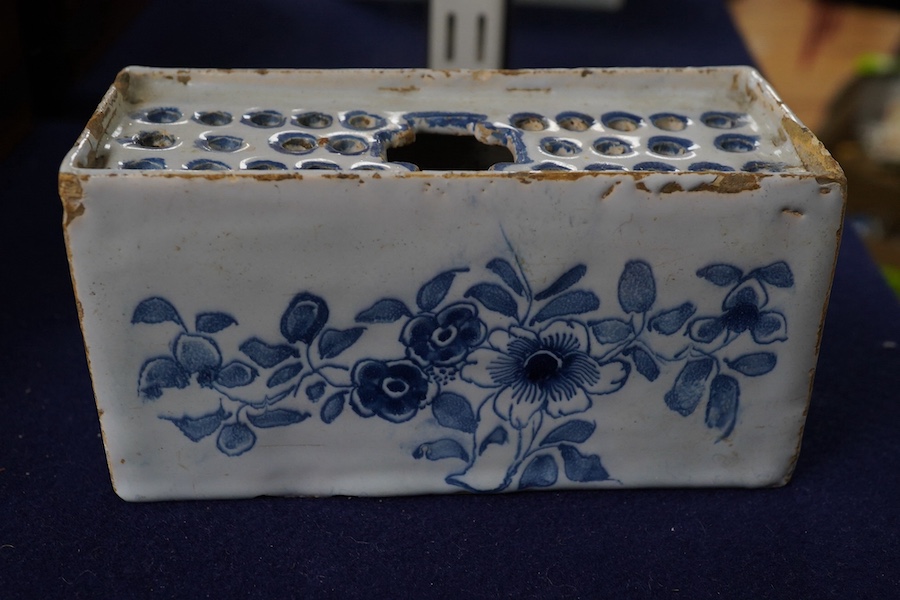 An 18th century English delftware flower brick, 15cm wide, 8cm high. Condition - edges chipped and larger chip to one corner, usual for pottery type, use and age